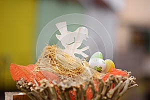 Easter decorations on the street of small town in France. Easter painted eggs and bird in nest. Garden decor