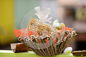 Easter decorations on the street of small town in France. Easter painted eggs and bird in nest. Garden decor