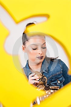 Easter Delight: Woman with Easter Egg Through Yellow Frame in Rabbit-Shaped Cutout