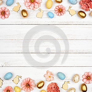 Easter double border with eggs, paper flowers and wooden bunnies against a square white wood background