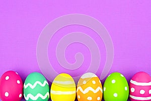 Easter egg bottom border over purple paper background