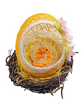 Easter egg and chicken made of thread and paper in a nest of birch twigs