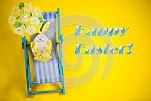 Easter egg in deck chair, yellow background, holiday on easter