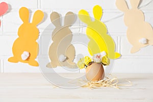 Easter egg decoration. Easter egg decorated with yellow roses wreath and paper bunnies