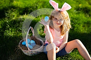 Easter egg hunt. Happy Easter. Kids in bunny ears with Easter egg in basket. Boy play in hunting eggs.