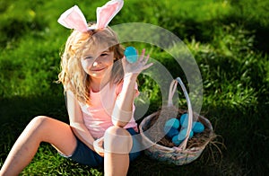 Easter egg hunt. Happy Easter. Kids in bunny ears with Easter egg in basket. Boy play in hunting eggs.