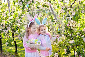 Easter egg hunt. Kids with bunny ears and basket