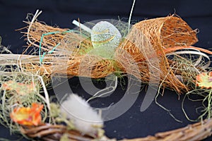 Easter egg and orange net. Wreath wicker decorated. Black background image.