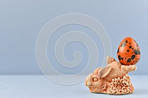 Easter egg. Rabbit holds a quail egg