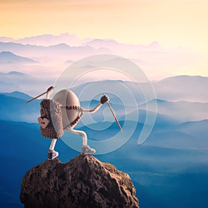 Easter egg with raised hands standing on a mountain top