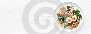 Easter egg salad with prosciutto and broccolini on white background, top view. Easter salad with boiled egg. Banner