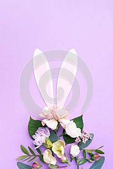 Easter egg shape made of colorful spring flowers and green leaves. Minimal holiday concept.