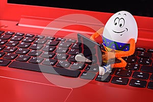 Easter egg sitting on a keyboard of notebook