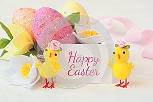 Easter egg, spring flowers and chickens on a white background and the inscription happy Easter . Festive Easter card