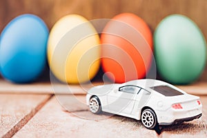 Easter egg and toy car on wooden background