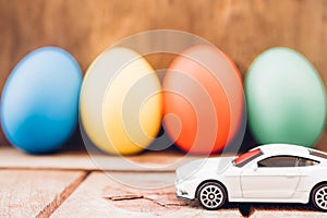 Easter egg and toy car on wooden background