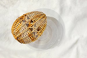 An Easter egg woven from straw lies on the table