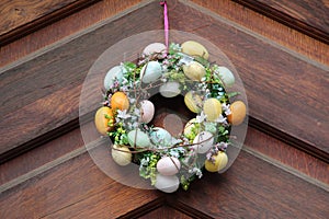 Easter egg wreath hanging on a wooden door