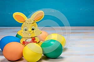 Easter egge on blue rustic wooden background in circle with color rabbit in