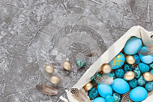 Easter eggs in basket on gray concrete background. Top view, flat lay, copy space
