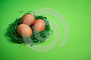 Easter eggs in a basket on green paper background