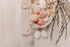 Easter eggs in basket on grey wooden background, rustic style