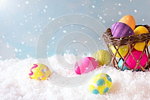 Easter Eggs and Basket in the Snow Scene outside with sky background with room or space for copy, text or your words. Horizontal