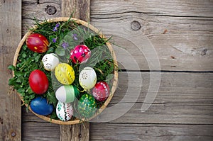 Easter eggs in basket top view on wooden background. Happy Easter concept card. Happy Easter eggs on wooden background.