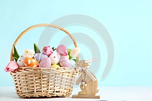 Easter eggs in basket with tulip flowers