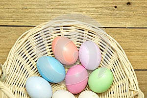 Easter eggs in the basket on wood background
