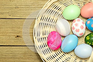Easter eggs in the basket on wood background