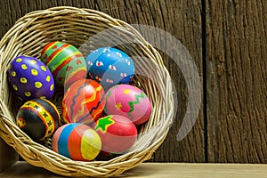 Easter eggs in basket and wood background