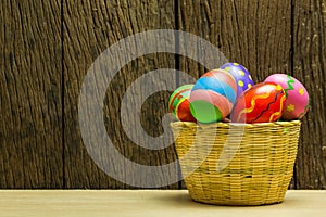 Easter eggs in basket and wood background