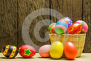 Easter eggs in basket and wood background