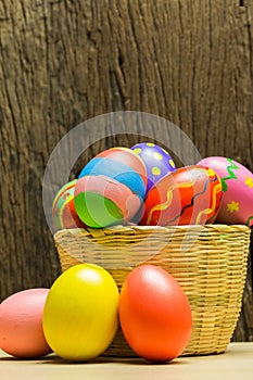 Easter eggs in basket and wood background
