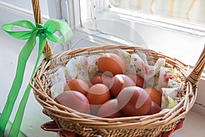 Easter eggs in the basket of wooden boards