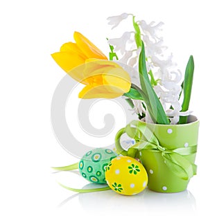 Easter eggs in basket with yellow tulip flowers