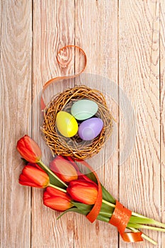 Easter Eggs in a birds nest with colorful tulips