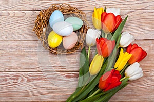 Easter Eggs in a birds nest with colorful tulips