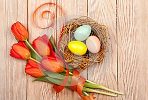 Easter Eggs in a birds nest with colorful tulips