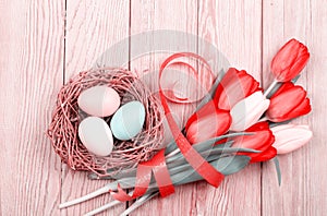 Easter Eggs in a birds nest with colorful tulips