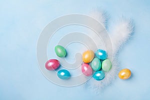 Easter eggs and bunny ears on blue table from above. Childrens Easter background. Copy space for text.