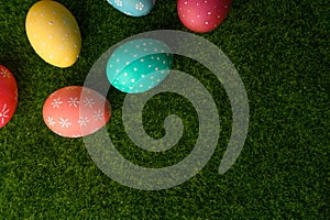 Easter eggs colored on green grass. Congratulations on Easter. Horizontal frame