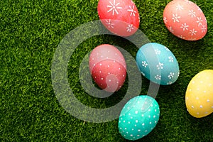 Easter eggs colored on green grass. Congratulations on Easter. Horizontal frame