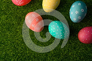 Easter eggs colored on green grass. Congratulations on Easter. Horizontal frame