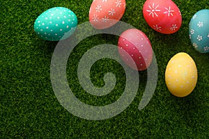Easter eggs colored on green grass. Congratulations on Easter. Horizontal frame