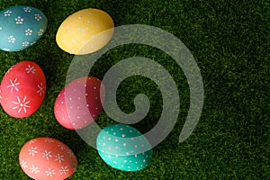 Easter eggs colored on green grass. Congratulations on Easter. Horizontal frame