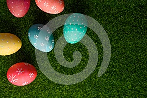 Easter eggs colored on green grass. Congratulations on Easter. Horizontal frame