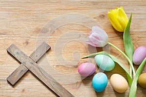 Easter eggs and cross on abstract wooden spring background