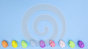 Easter eggs different colors move left right on bottom of blue theme. Stop motion